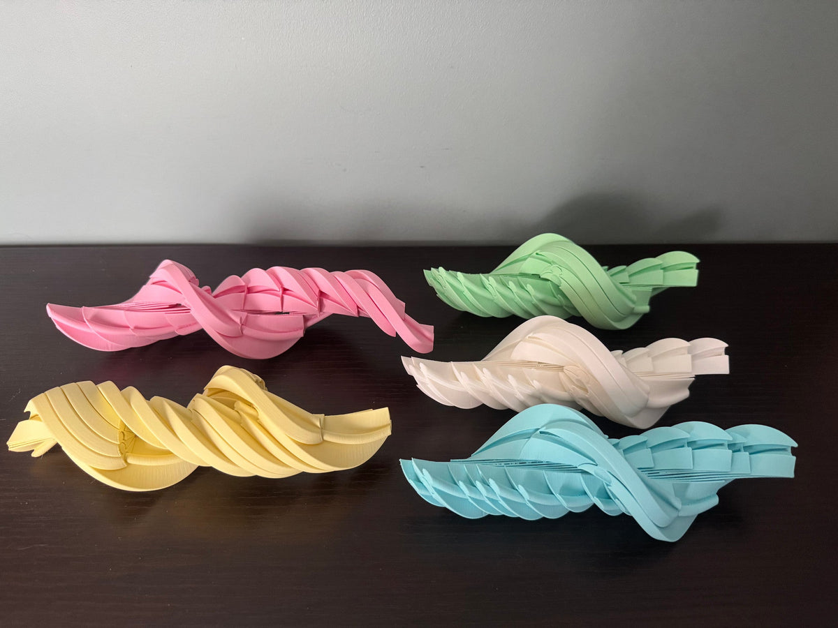 Easter Egg Spiral Fidgets — five eggs fully extended into flat spirals in pink, yellow, green, cream and blue.