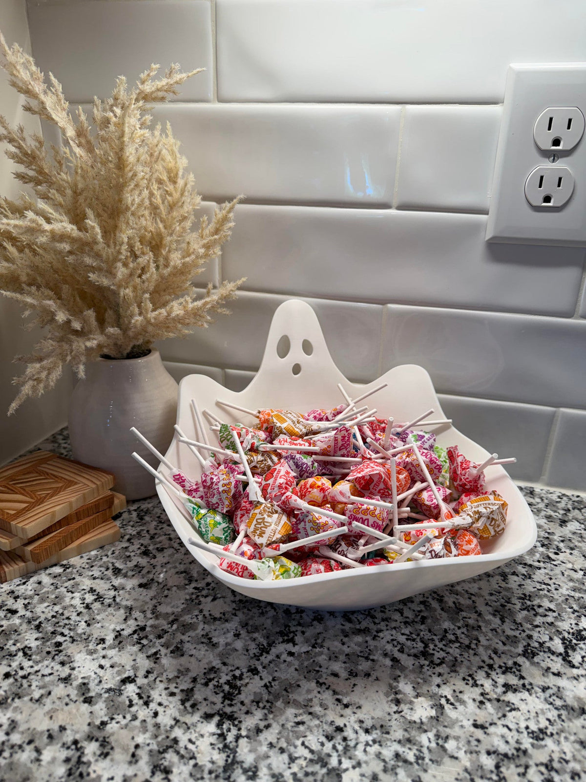 Ghost Candy Bowl — a white ghost-shaped bowl with a wavy rim and cut-out eyes, filled with wrapped lollipops.