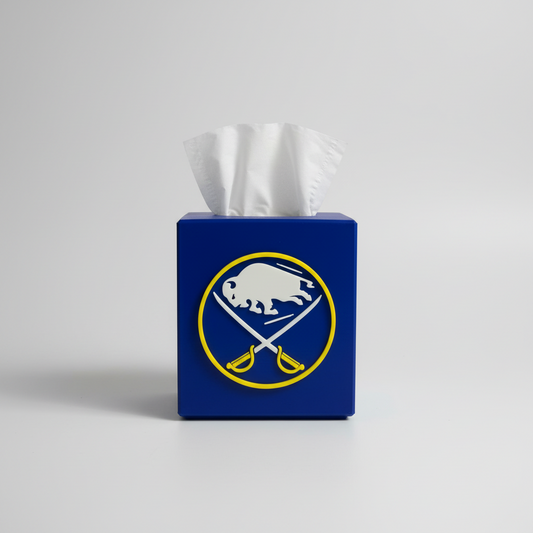 Blue & Gold Hockey Tissue Box Cover — a blue square tissue box cover with a raised front emblem, tissue drawn through the top, on a soft light-gray studio background.