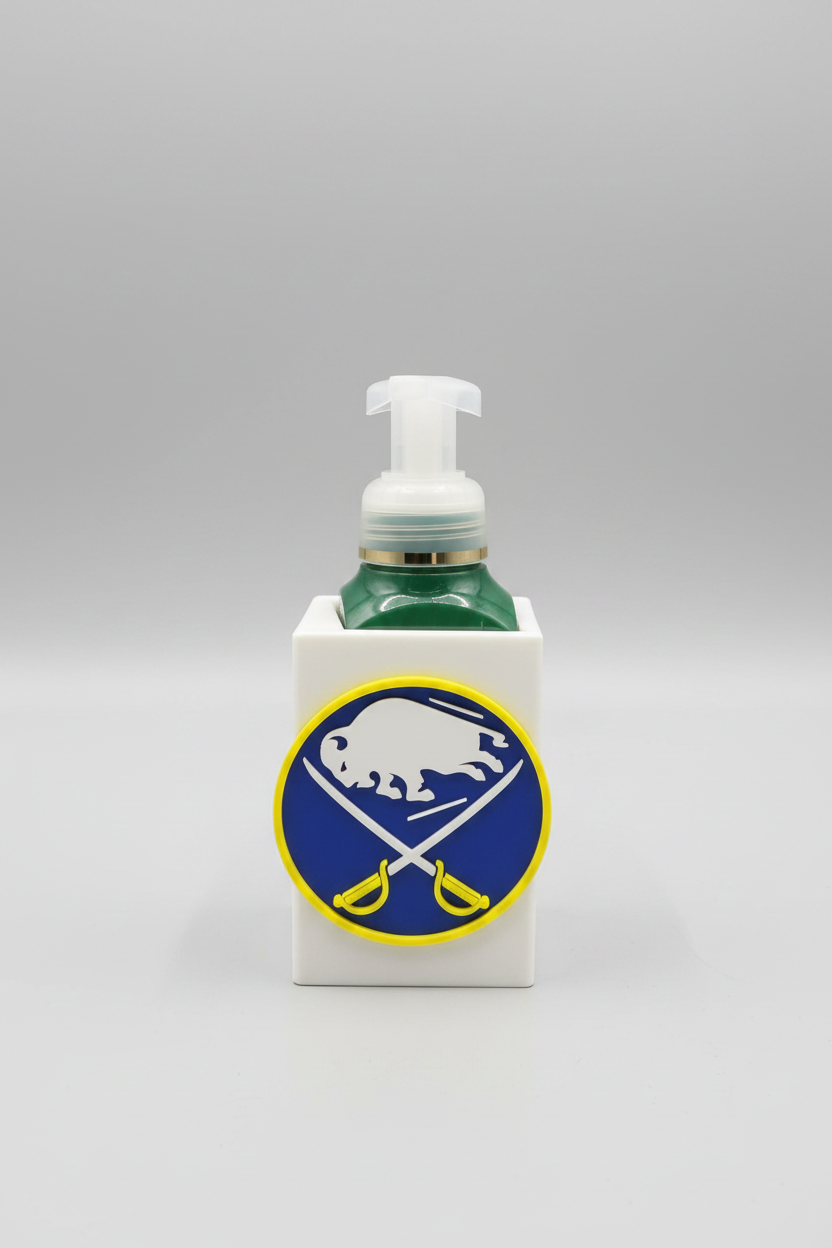 Buffalo Hockey Soap Dispenser Holder — a white square sleeve with a raised front emblem, holding a green foaming soap bottle, on a soft light-gray studio background.