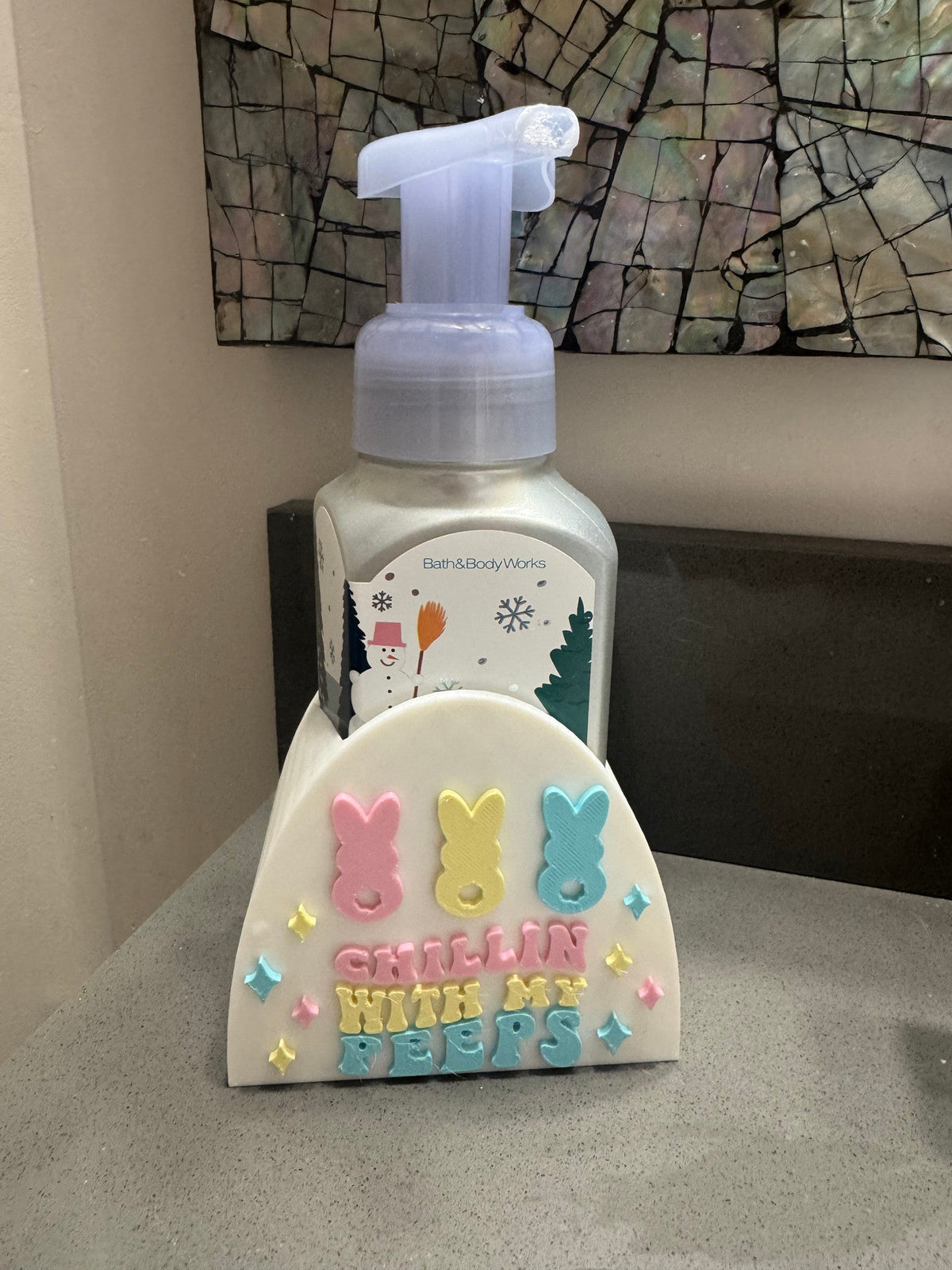 Chillin' With My Peeps Soap Dispenser Holder — a pastel holder with marshmallow-bunny shapes and raised lettering, holding a foaming soap bottle on a counter.