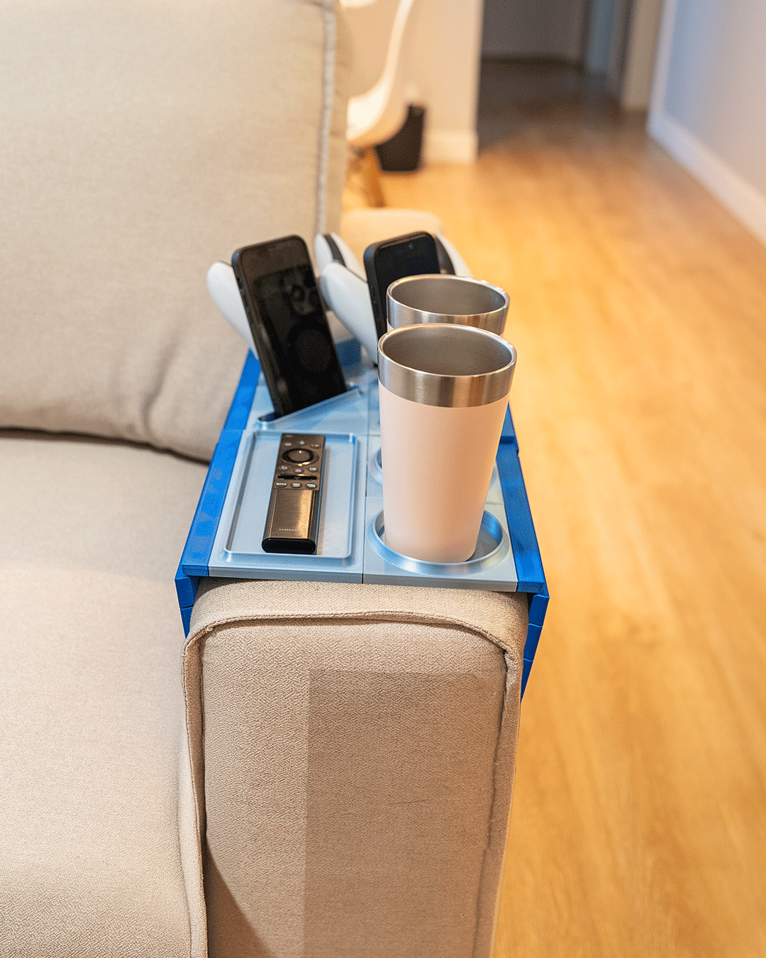 Couch Co-Op — Modular Sofa Side Table — a blue tray on a sofa arm holding two tumblers, a games controller and a remote.