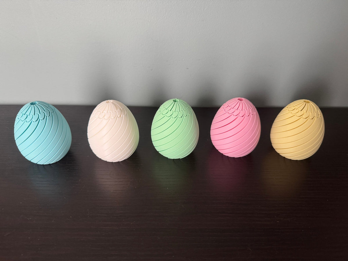 Easter Egg Spiral Fidgets — five pastel eggs in blue, cream, green, pink and yellow closed in a row.