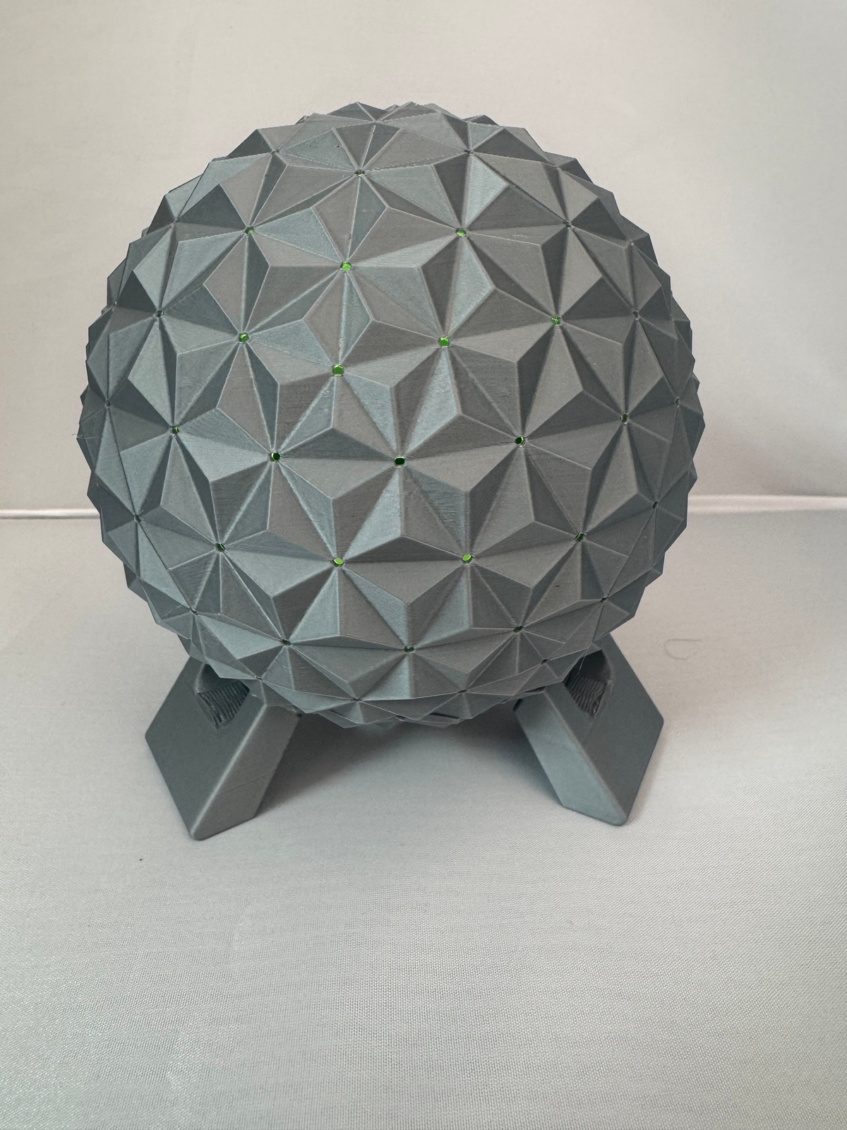 Geodesic Sphere Lamp with RGB Lights — a grey faceted geodesic sphere on a three-legged stand, lit green at the facet points.
