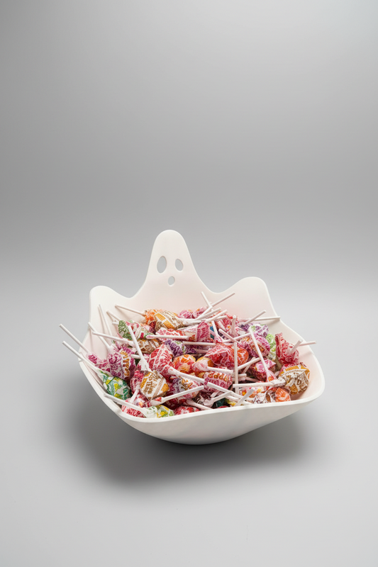 Ghost Candy Bowl — a white ghost-shaped bowl with a wavy rim and cut-out eyes, on a soft light-gray studio background.