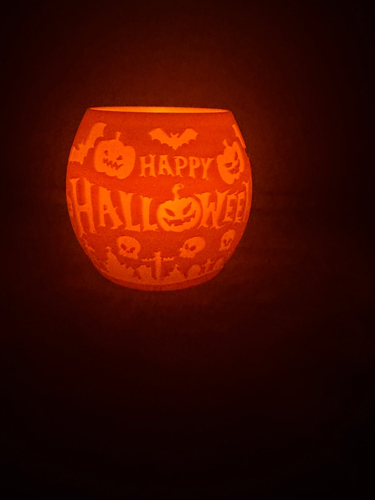 Happy Halloween Pumpkin Lantern — the orange lantern lit from within, its carved HAPPY HALLOWEEN lettering, pumpkins and bats glowing.