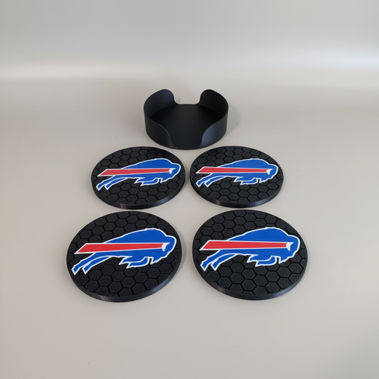 Hex Coaster Set — Buffalo — four round black coasters with a honeycomb texture and a raised front emblem, plus a matching black holder, on a soft light-gray studio background.