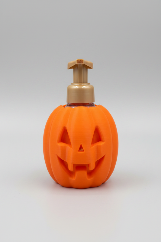 Jack-O'-Lantern Soap Dispenser Holder — an orange carved pumpkin holder with a toothy grin, sized for a foaming soap bottle, on a soft light-gray studio background.