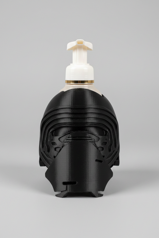 Masked Knight Soap Dispenser Holder — a black helmet-shaped holder styled like a dark knight or warrior, with a white and yellow foam soap dispenser mounted on top, on a soft light-gray studio background.