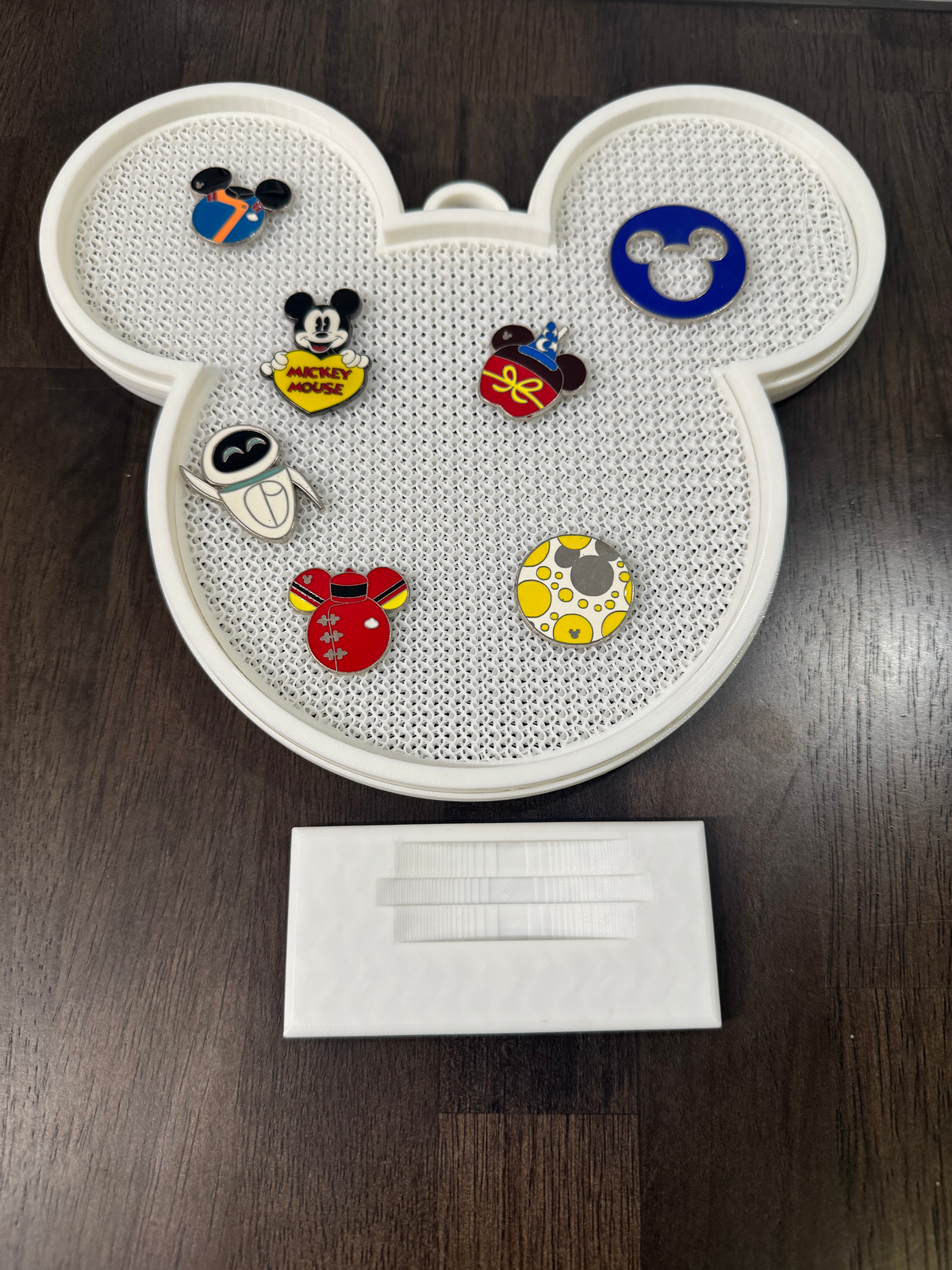 Mouse Head Pin Display Board — the white pin board shown off its stand on a wood table with the separate base piece beside it.