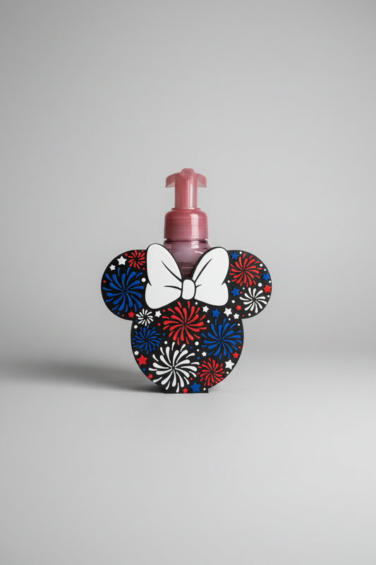Patriotic Bow Mouse Soap Dispenser Holder — a mouse-shaped pump bottle with a red, white, and blue fireworks pattern and a white bow, on a soft light-gray studio background.