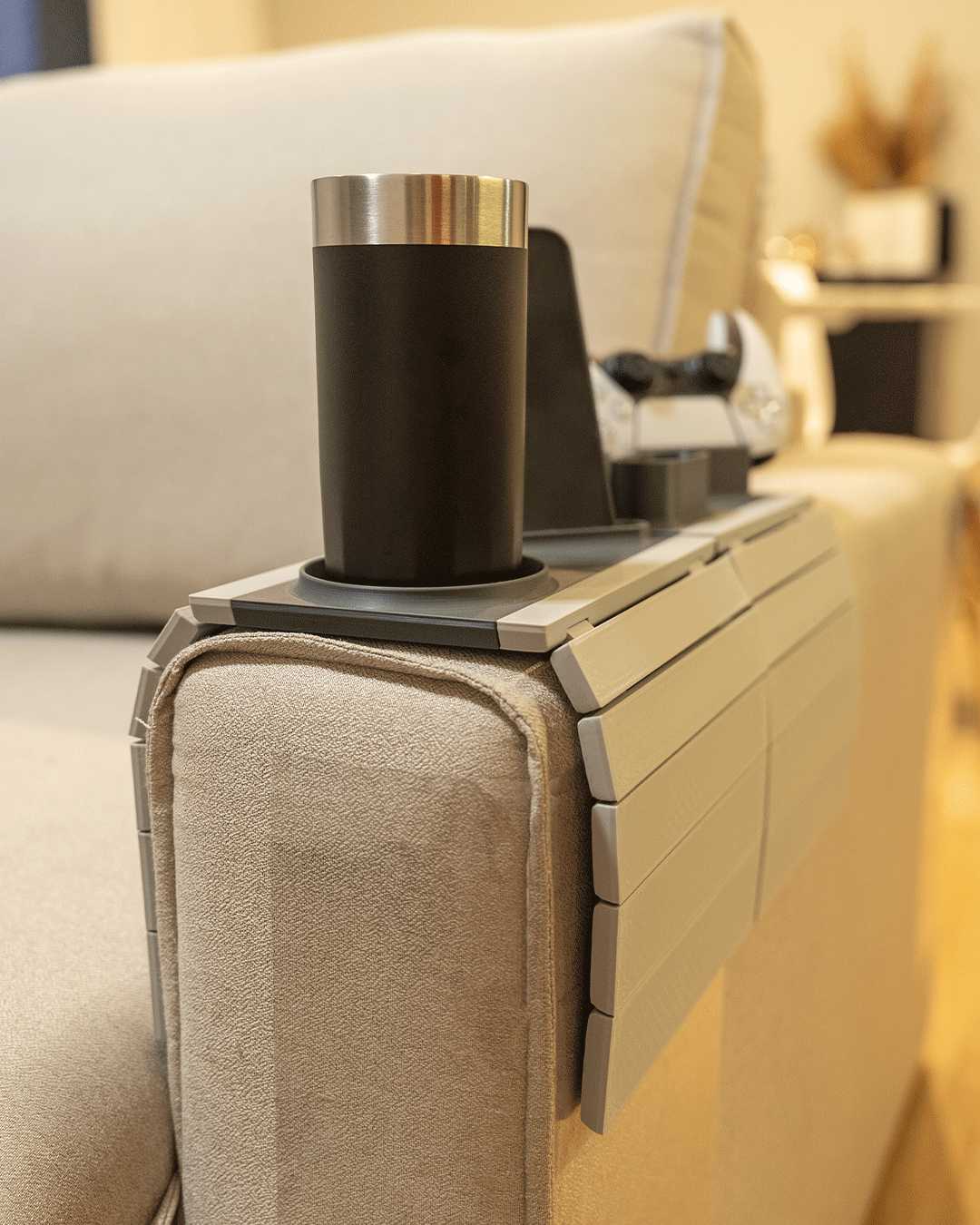 Player One Modular Sofa Side Table — close view of the flexible slatted tray conforming to a cream sofa arm with a tumbler in the cup holder.