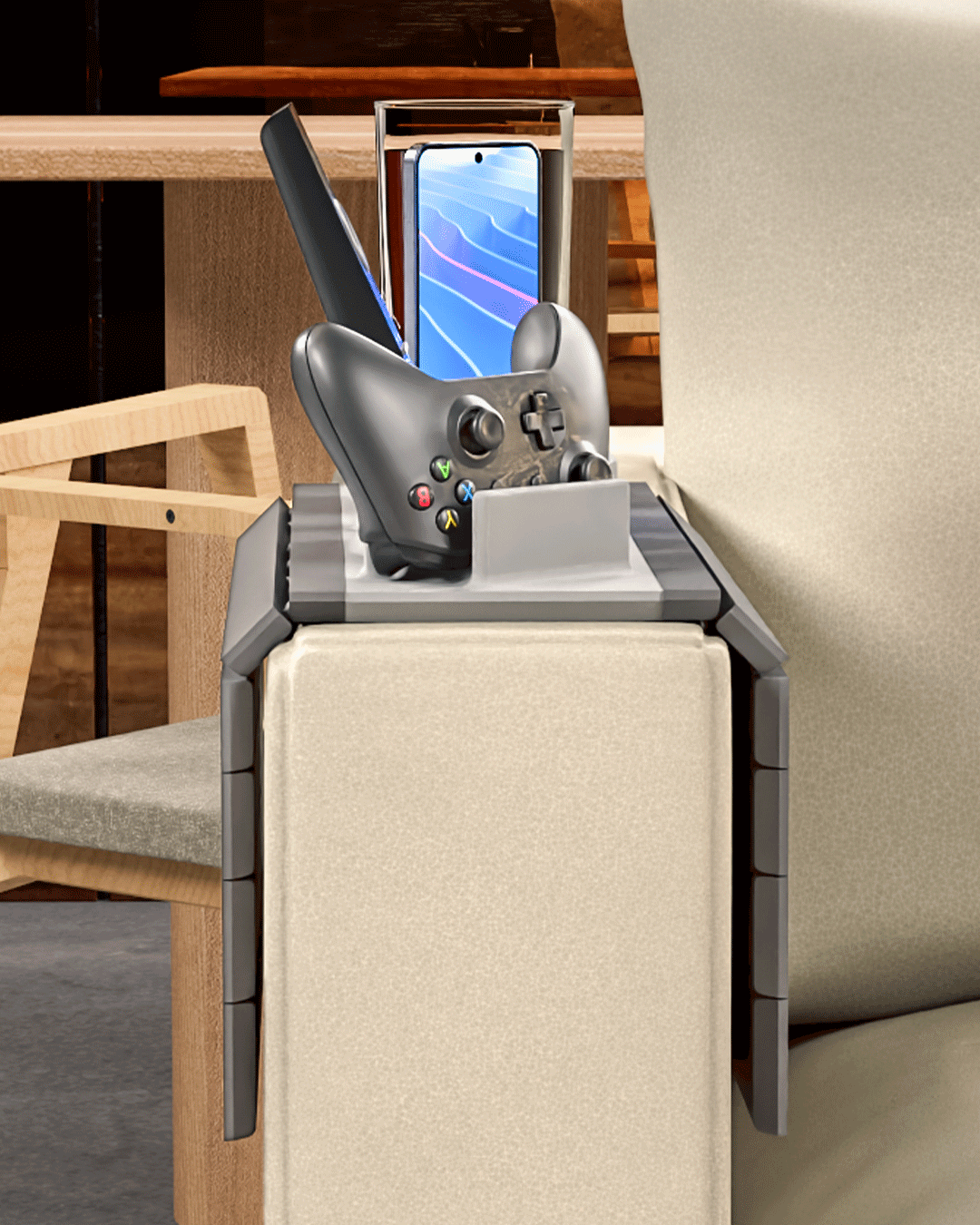 Player One Modular Sofa Side Table — the slatted tray folded over a sofa arm with a phone upright in its slot and a controller resting in the cradle.