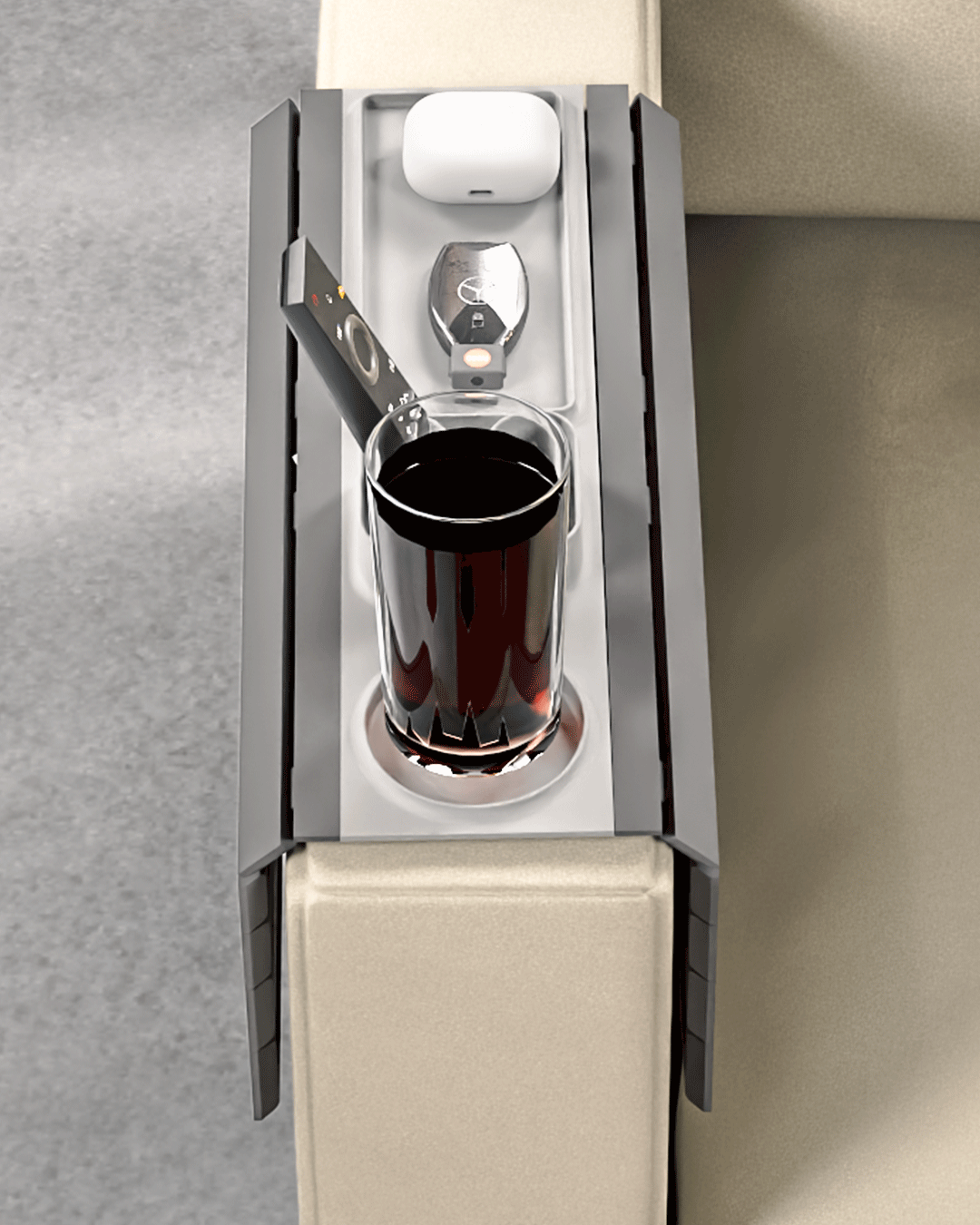 Prime Time Modular Sofa Side Table — overhead view of the tray showing the cup holder with a glass, remote slot, and earbud case in the tray.