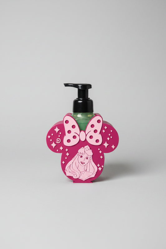 Princess Bow Soap Dispenser Holder — a pink and magenta rounded holder with two ear shapes and a polka-dot bow, holding a green bottle, on a soft light-gray studio background.