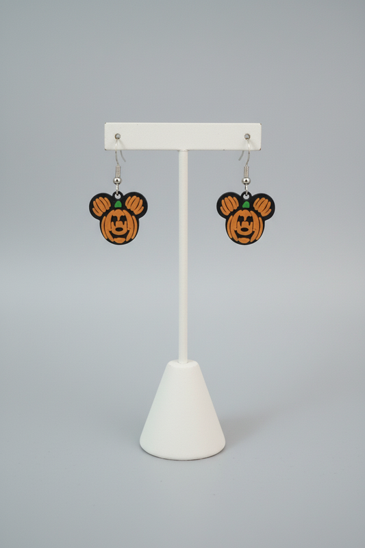 Pumpkin Mouse Earrings — a pair of mouse-eared, pumpkin-faced dangling earrings, on a soft light-gray studio background.