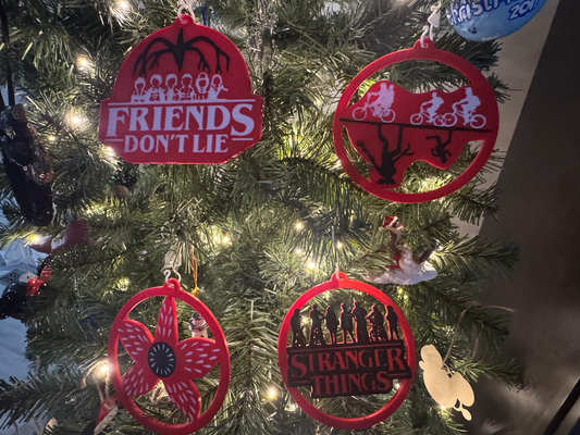 Retro Sci-Fi Ornaments — a set of four red flat ornaments hanging on a lit Christmas tree.