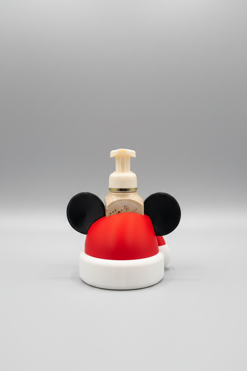 Santa Hat Mouse Soap Dispenser Holder — a beige pump bottle with a gold collar, shaped like a Santa hat with black mouse-ear details, on a soft light-gray studio background.