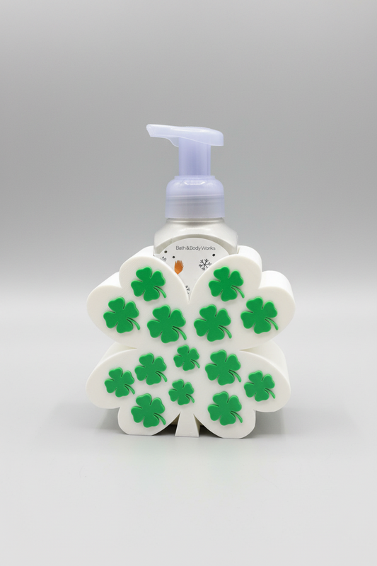 Shamrock Soap Dispenser Holder — a St. Patrick's Day themed foam soap dispenser in a white flower-shaped holder decorated with green shamrocks, on a soft light-gray studio background.