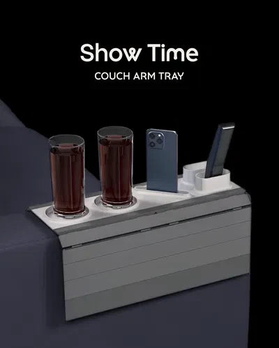 Show Time Modular Sofa Side Table — a grey slatted couch arm tray with two cup holders, a phone slot and a remote slot, holding two drinks and a phone.