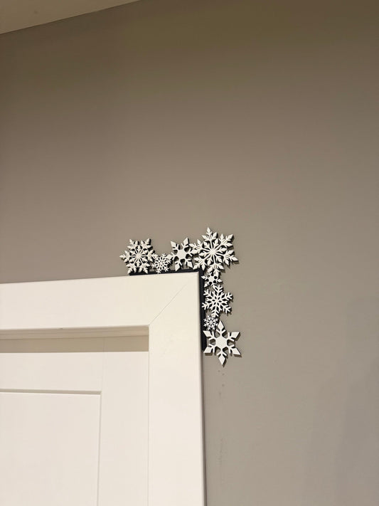 Snowflake Cluster Corner Door Topper — a cluster of white snowflakes arranged along the top corner of a white door frame.