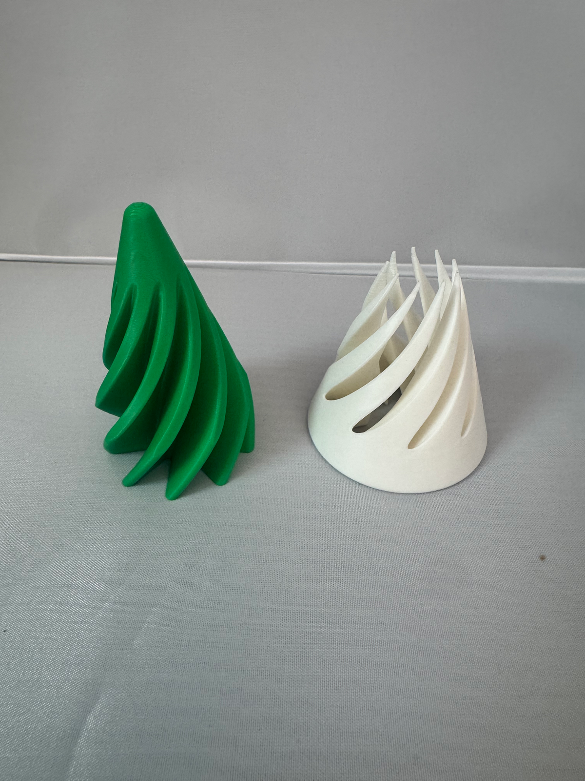 Spiral Pass-Through Fidget — two spiral cone fidgets, one green and one white, shown side by side.