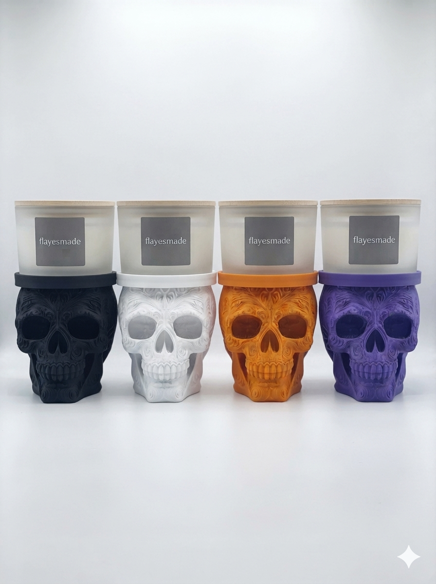 Sugar Skull Candle Holder — all four colorways shown side by side, black, white, orange and purple, each a filigree-relief skull topped with a matching collar ring holding a lidded frosted-white jar candle, on a soft light-gray studio background.